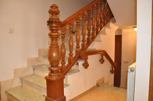 Barandilla y pasamanos barnizado de madera con pilastra tallada