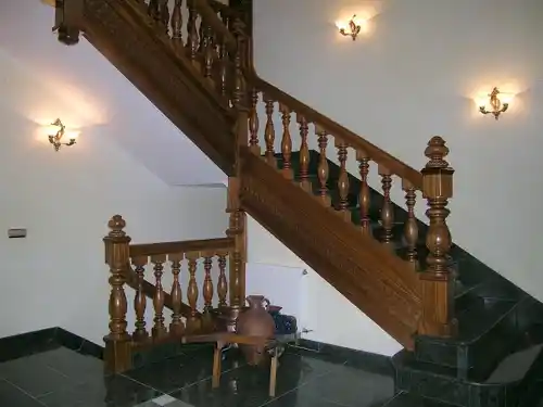 Barandilla de madera de iroko barnizado con faja tallada artesanalmente