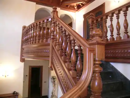 Barandilla de madera de iroko barnizado con faja tallada artesanalmente