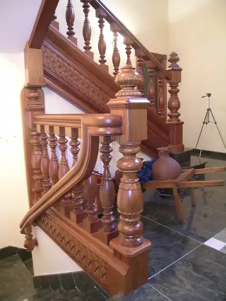 Barandilla de madera de iroko barnizado con faja tallada artesanalmente