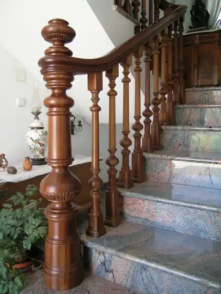 Barandilla de madera curva con pilastra tallada a mano