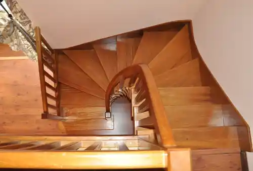 Escalera madera con barandilla curva y peldaños compensados