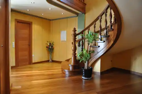 Escalera madera clásica con balaustres torneados y pasamanos curvo