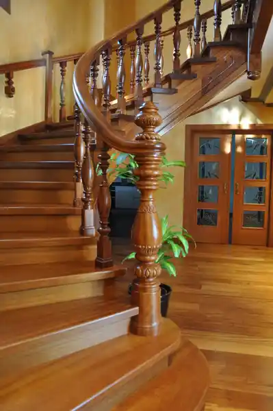 Escalera madera clásica con balaustres torneados y pasamanos curvo