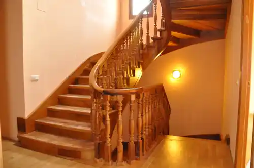 Escalera madera clásica con balaustre torneado y pasamanos curvo