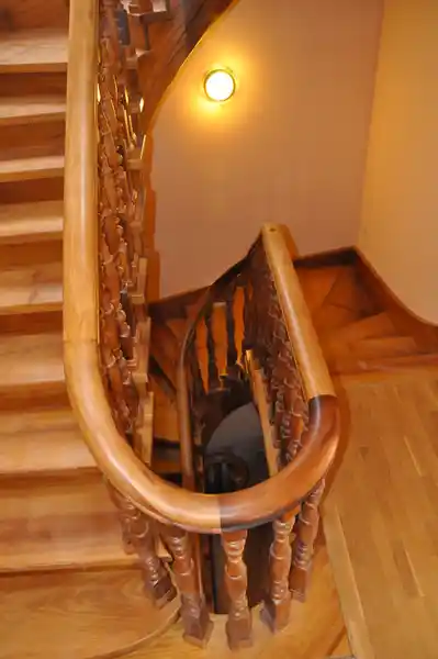Escalera madera clásica con balaustre torneado y pasamanos curvo