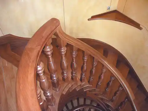 Escalera madera con pasamanos curvo y balaustre torneado